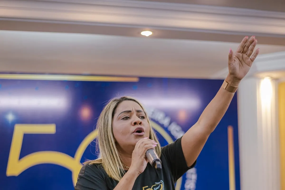 Cantora conduzindo o louvor de mão levantada