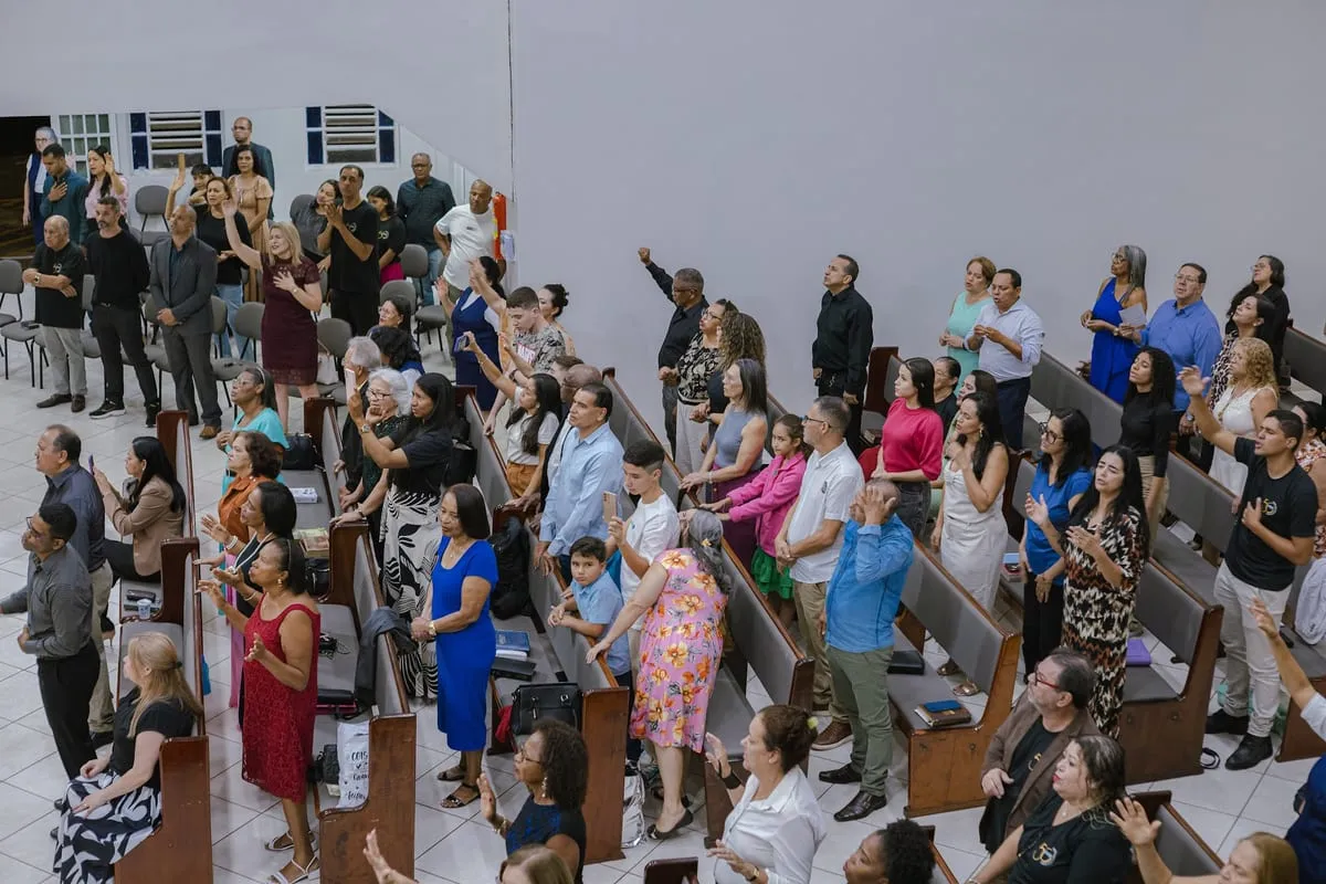Igreja de pé durante o momento de oração